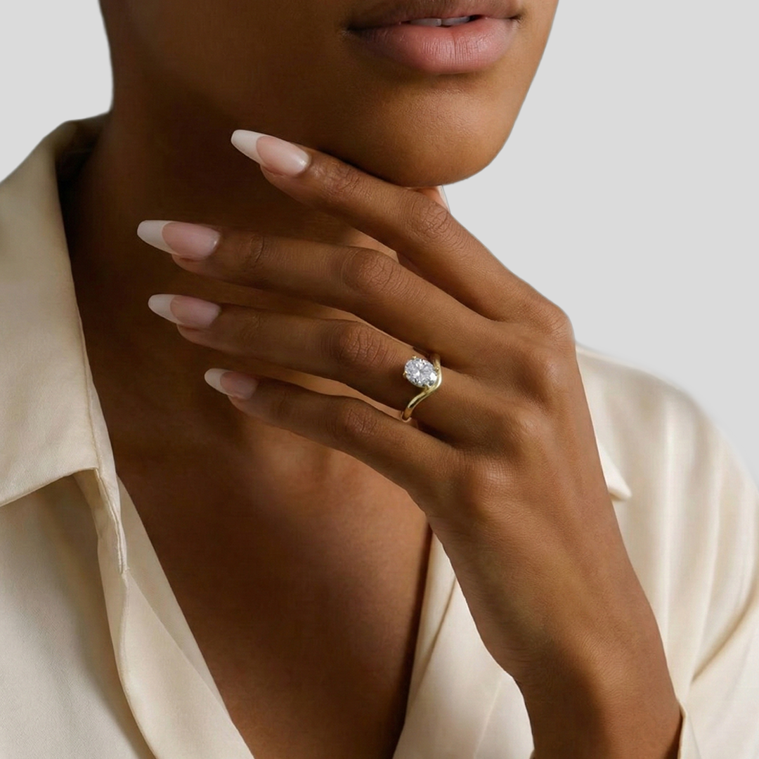Woman wearing curved band oval diamond solitaire ring