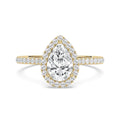 A pear-cut diamond engagement ring in yellow gold with a halo and pavé band, centered on a clean white background.
