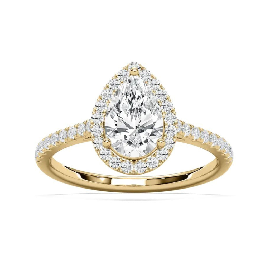 A yellow gold ring featuring a pear-cut diamond center stone surrounded by a halo of smaller round diamonds, with a pavé-set diamond band, shown on a clean white background.