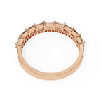 Rose gold wedding ring with embedded stones on a white background
