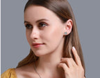 Woman wearing round halo diamond stud earrings