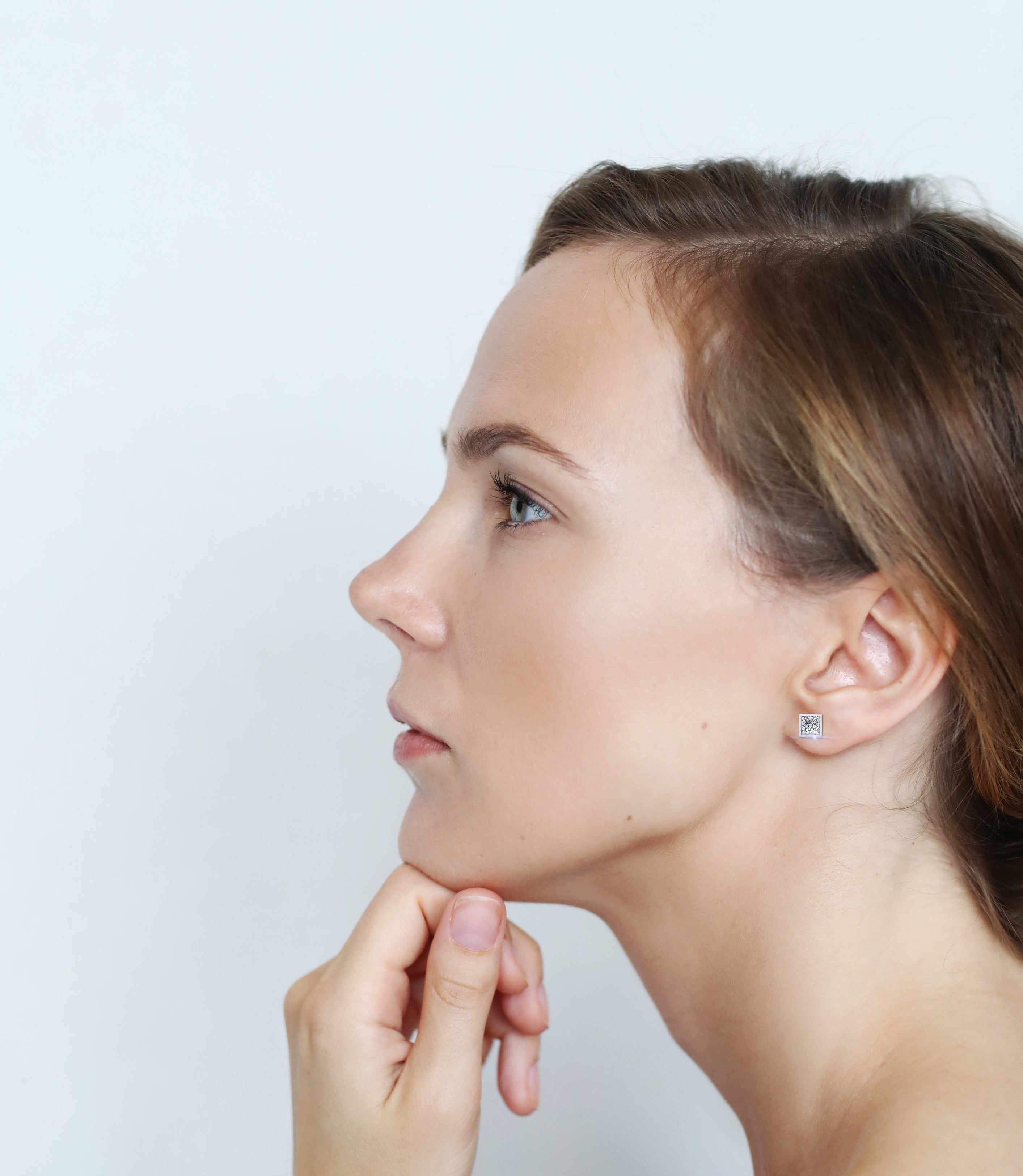 Woman wearing princess cut diamond studs 