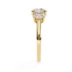 Gold engagement ring featuring three cushion cut diamonds