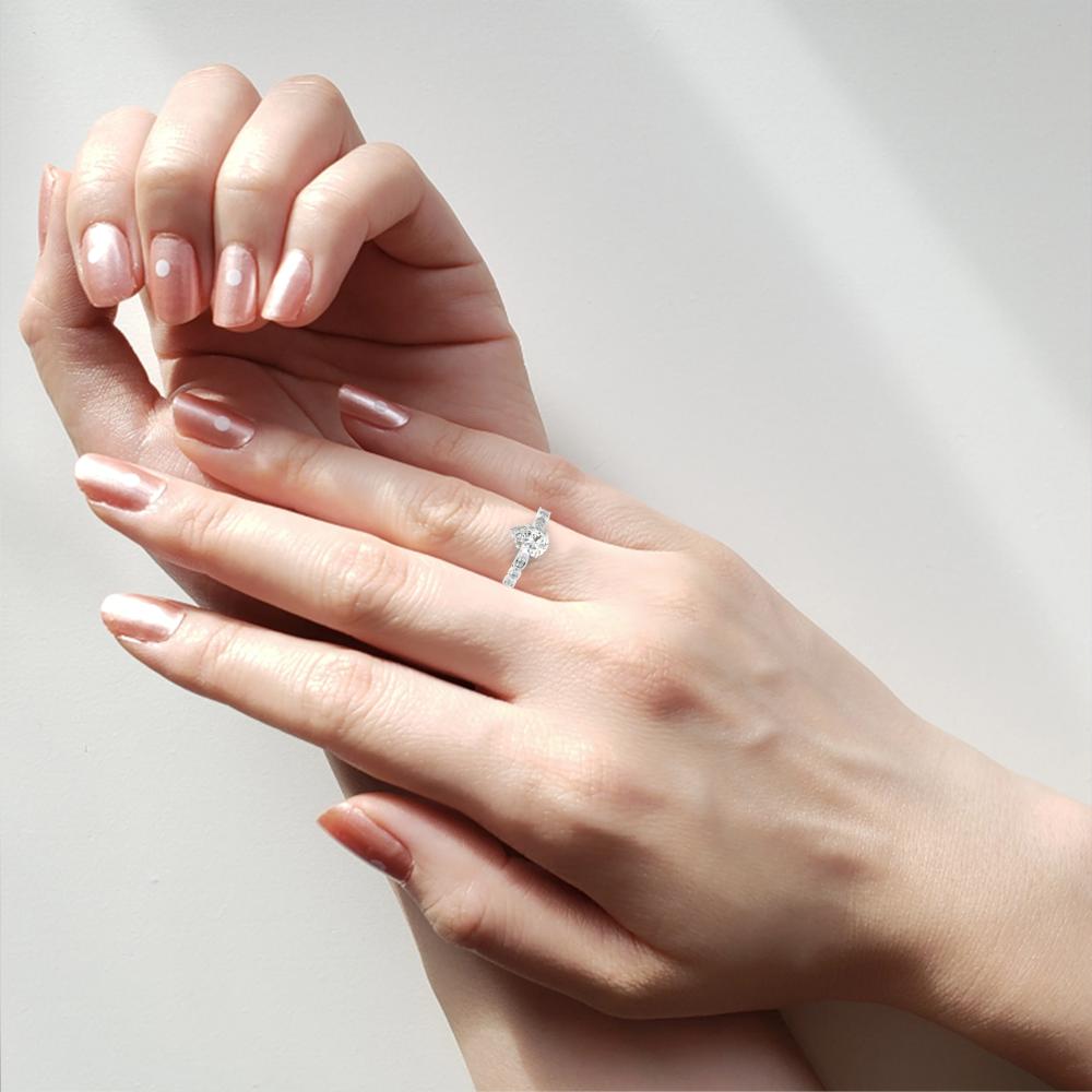 Woman wearing affordable engagement ring with pear shape solitaire diamond